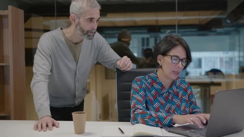 Man and Woman Collaborating in Modern Office