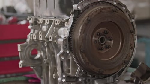 Hand Tightening Bolts Of Flywheel Gear Of Disassembled Car Engine In Repair Shop