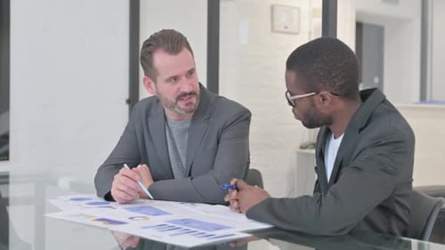 Men Reviewing Documents at Conference Table