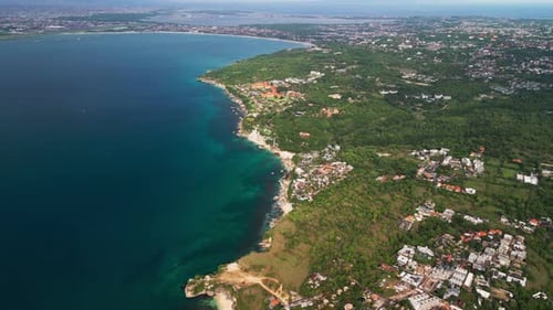 Drohnenblick aus großer Höhe auf zerklüftete Klippen und die türkisfarbene Küstenlandschaft in ganz Indonesien, Bali.