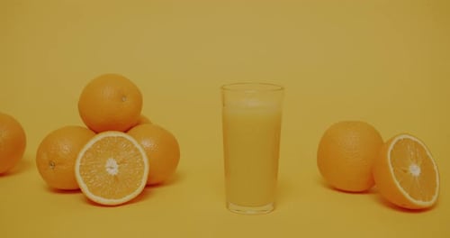 Fresh Orange Juice and Oranges on Yellow Background
