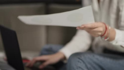 Woman Reviews Charts and Works On Laptop