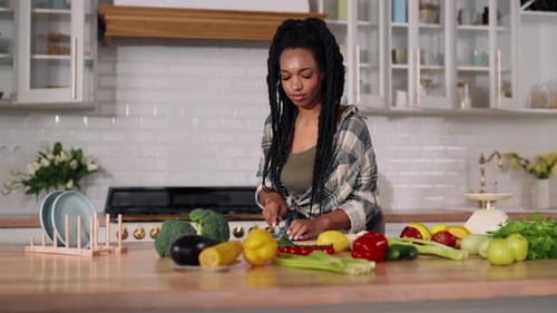 Woman Slicing Vegetables in Bright Kitchen for Cooking