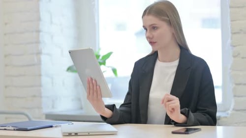 Young Woman Having Video Call on Tablet in Office