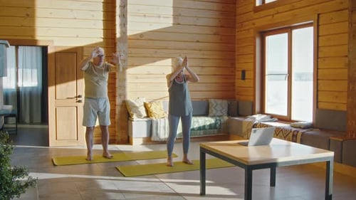 Senior Couple Practicing Yoga in Sunny Log Cabin