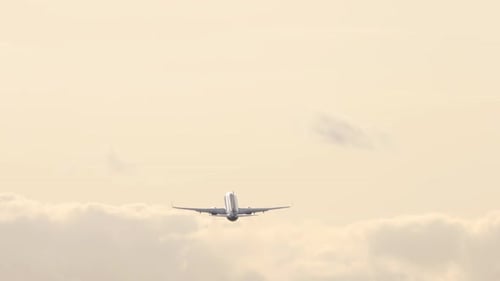 Airplane Ascends Into Cloudy Sky