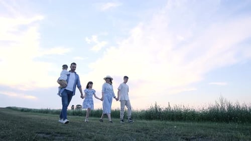 A Happy Family is Walking Through a Wheat Field They are Having Fun Together