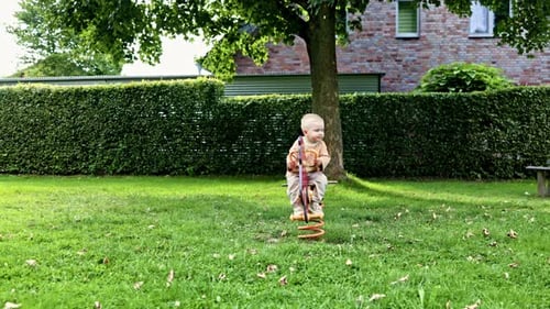 European playground. Boy 2 years old swings on a wooden horse