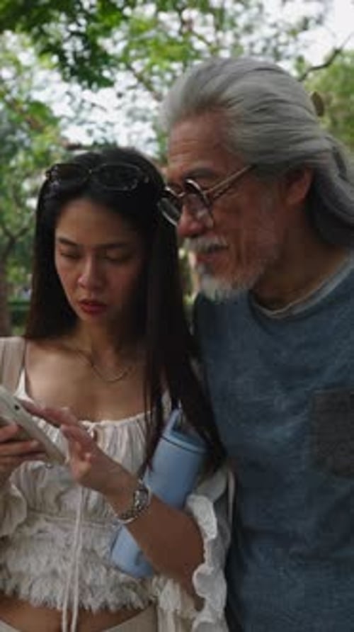 Woman and Man Use Cellphone in Urban Park