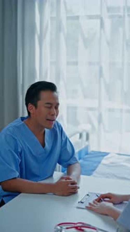 Vertical footage of Doctor examining patient in hospital.