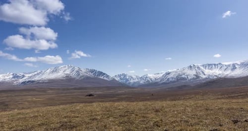 Timelapse of Sun Movement on Crystal Clear Sky with Clouds Over Snow Mountain Top