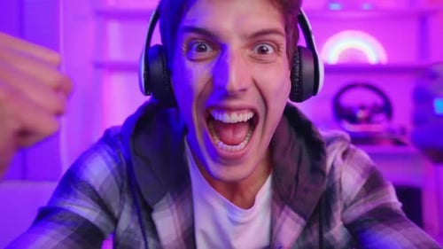 Excited Gamer Celebrating Success in Neon Room