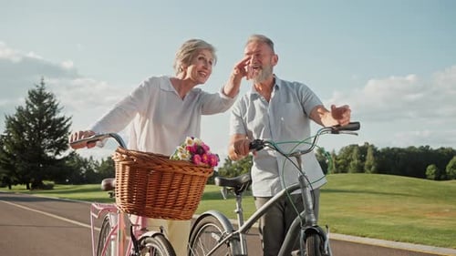 Happy Senior Couple Laughing With Bicycles in Park