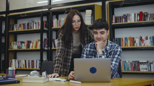 Des jeunes collaborent à un projet dans une bibliothèque confortable pendant la journée, entourés de