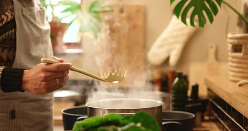 Woman stirs steaming pot in cozy kitchen setting