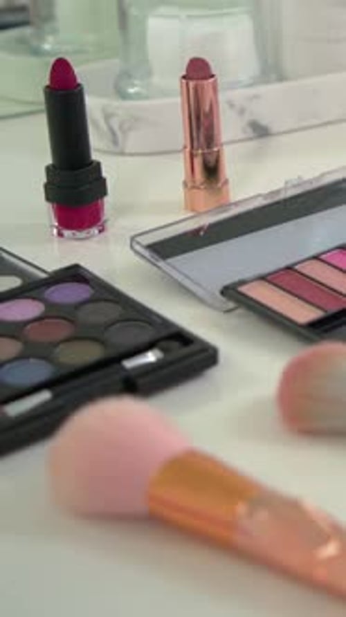 Vertikales Video: Kamera über dem Waschtisch schwenken, leuchtend pinker Lippenstift zum Vorschein bringen, Paletten zur Geltung bringen