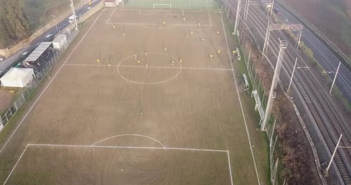 Aerial. Soccer game on a stadium placed between road and railway. Children age 14-15 soccer match cl