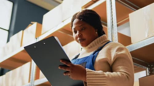 Woman Reviews Inventory in Warehouse Storage