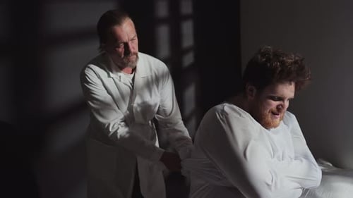 Doctor Securing Restraints on Patient in Hospital Room