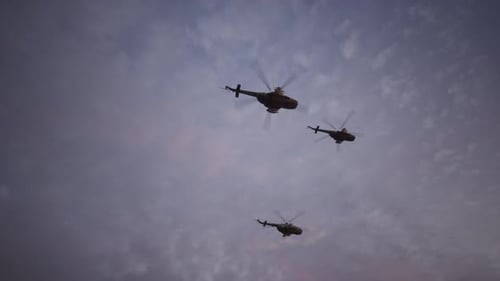 Military Helicopters Flying in Formation Against a Cloudy Sky
