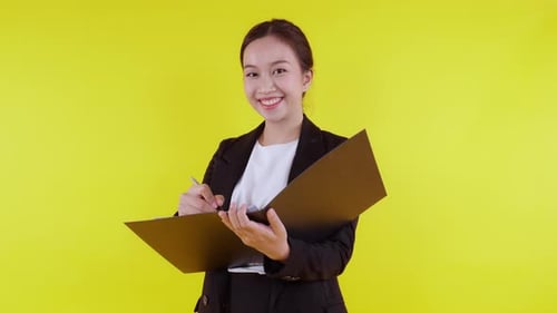 Portrait young asian businesswoman hold folder and writing record document with success.