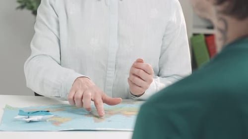 Woman Pointing to World Map with Travel Client