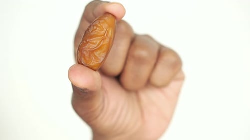 Close Up of Hand Holding a Date Fruit