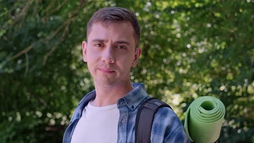 Forest running to boost productivity. A man stands in the park with a sports water bottle, hydrating