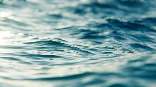 Close-up view of flickering ocean waves in slow motion, seamless loop background