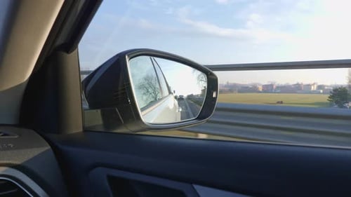 Traveling on the Highway in Italy: view from the Rearview Mirror, Cars following and Countryside and