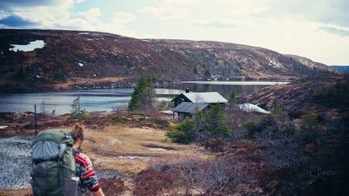 Hiker With His Dogs Walking Towards Reinsjoen Lake In Norway - Wide Shot