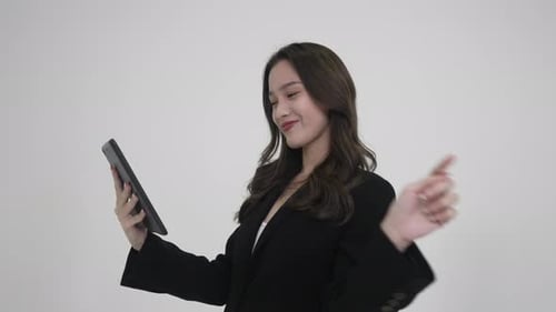 Woman Interacting with Tablet on Plain Background