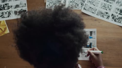 Top View of Illustrator Adding Highlights to Storyboard Sheets at Table