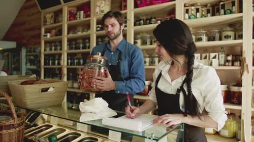 A Young Man and Woman Shop Assistant Working in a Zero-Waste Store