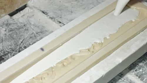 Mann gießt flüssigen Gips in Form