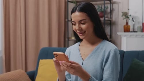 Smiling Woman Using Smartphone Indoors at Home