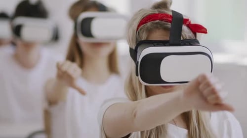 Enthusiastic Young Adults Using Virtual Reality Headsets Indoors