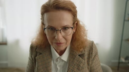 Mujer de mediana edad con gafas concentrada en escribir en una máquina de escribir vintage