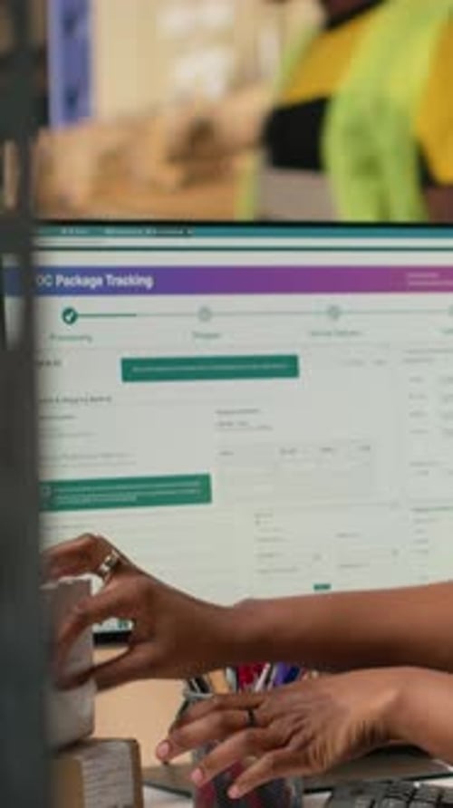Warehouse Worker Scanning Packages at Computer Workstation