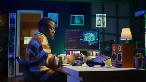 Young Adult Coding with Headphones at Desk