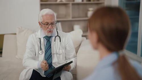 Senior Man Therapist Consults Woman Medical Appointment to Young Patient in Modern Clinic Female Has
