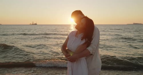 Couple Embracing in Sunset Light Standing Together on the Beach