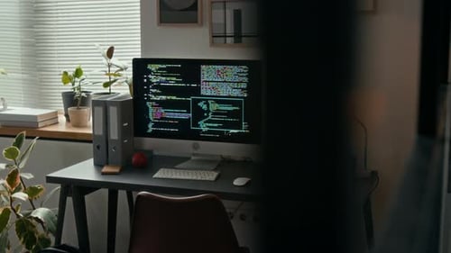 Computer mit Code auf dem Bildschirm auf grauem Holzschreibtisch im modernen Büro