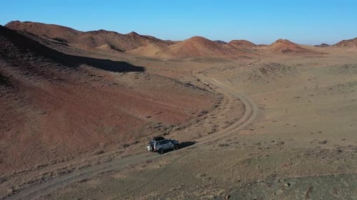 Cinematic drone shot of a lone car traveling in the Charyn Canyon, Kazakhstan