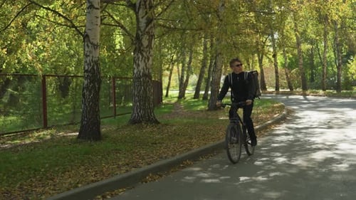 Autumn Park Courier Ride Cyclist Navigating Leafstrewn Suburban Pathway Courier on Bicycle Riding