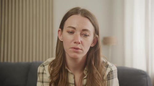 Jeune femme engagée dans un appel vidéo écoutant attentivement et répondant naturellement