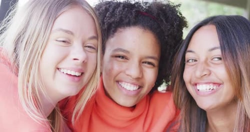 Portrait of happy diverse teenager girls friends embracing at home, slow motion