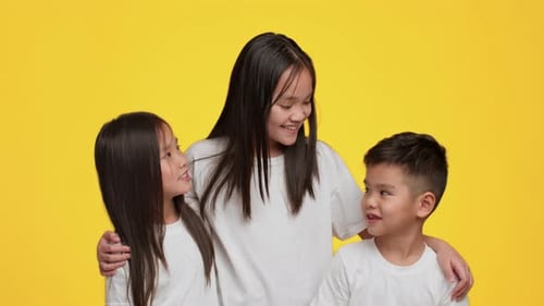 Smiling Children Posing Together in Studio on Yellow Background