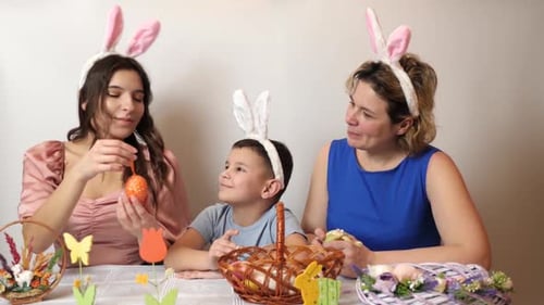 38 1/ Mother, daughter and son are looking at Easter eggs. Celebrating Easter in the family. Easter