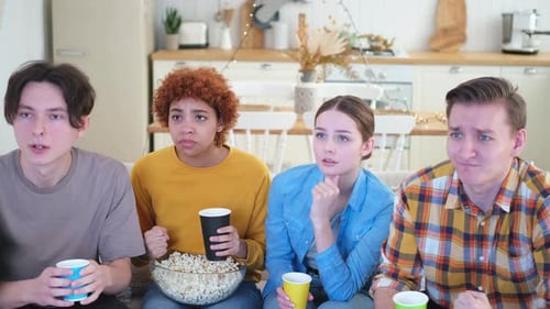 Friends Watching Television with Intense Reactions Indoors
